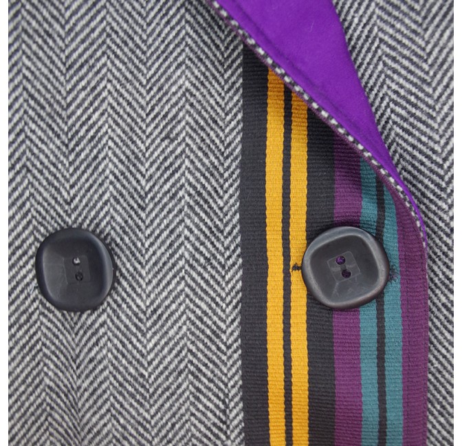 Manteau en laine chevron gris croisé avec ceinture et ganse coloré sur le devant, détail de la ganse coloré du devant